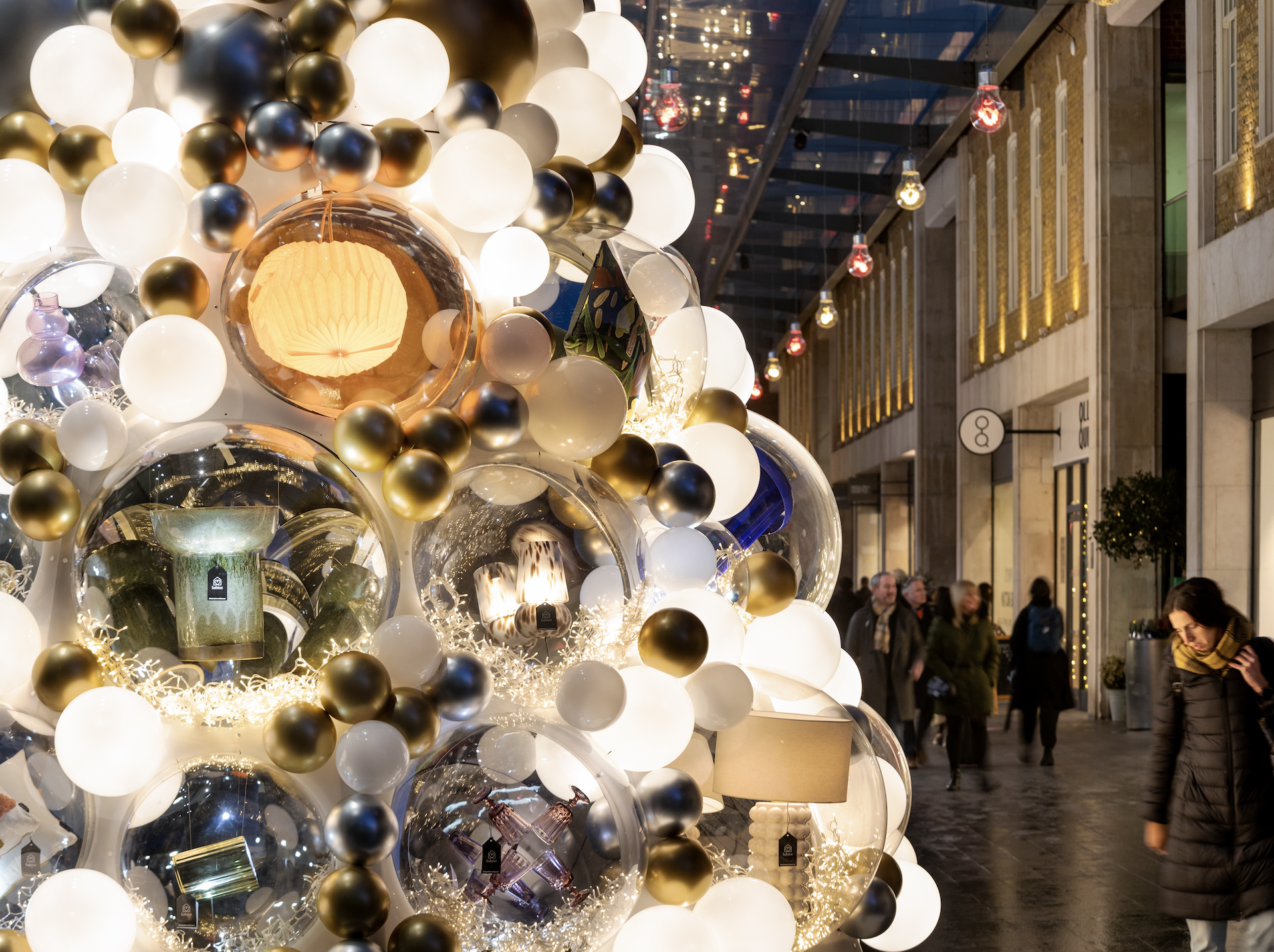 Visitors admire a silver, gold and white Christmas tree at Spitalfields Market, under new permanent lights installed by We Are Placemaking. The permanent lights are an example of how developers and visitors can benefit from cap-ex and permanent placemaking installations.